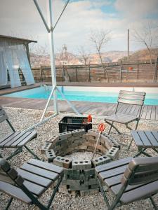 a fire pit with chairs and a swimming pool at Dohwa Pension Cheongju in Cheongju