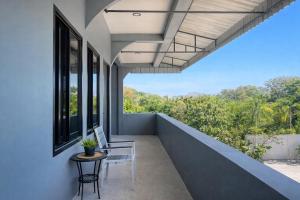 a balcony with a table and chairs and a window at The Homey Boutique Rawai in Rawai Beach