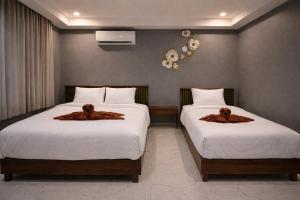 a bedroom with two beds with brown robes on them at The Homey Boutique Rawai in Rawai Beach