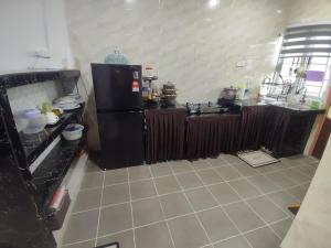a kitchen with a black refrigerator and a stove at k homestay in Jeli