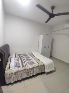 a bedroom with a bed and a ceiling fan at k homestay in Jeli