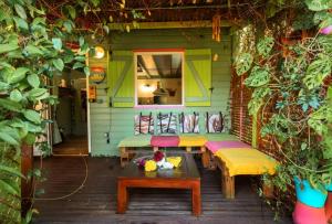 a patio with benches and a table on a house at LE TI CITRON VERT - Baignoire à ciel ouvert et refuge coloré - in Saint-Leu