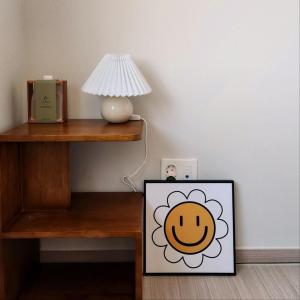 a table with a lamp and a picture of a flower at Donghae Eoul Stay in Donghae