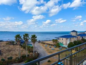 a view of a beach with palm trees and the ocean at Udo Daol Pension in Jeju