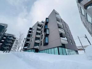 a building with a pile of snow in front of it at HOTELA Niseko Towers in Kutchan