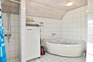 a bathroom with a tub in a tiled room at 377-Harboore-Fourmivej-56 in Harboør +23 photos