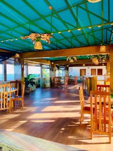 a restaurant with wooden tables and chairs and a blue ceiling at Alzurich Private Resort in Dauin