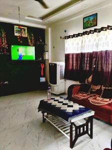 a living room with a couch and a tv at Haripriya Guest House 2bhk Solapur in Bāle