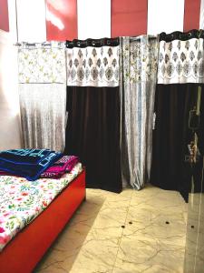 a bedroom with black and white curtains and a bed at Haripriya Guest House 2bhk Solapur in Bāle +5 photos