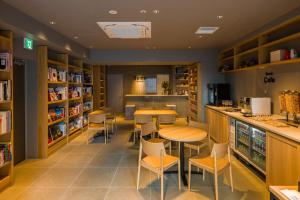 a restaurant with a bar and tables and chairs at Sumu Ueno East in Tokyo