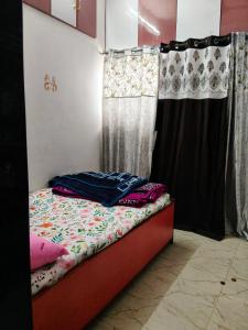 a bed in a room with two curtains and a bed sidx sidx sidx at Haripriya Guest House 2bhk Solapur in Bāle