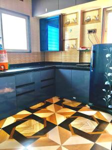 a kitchen with black cabinets and a checkered floor at Haripriya Guest House 2bhk Solapur in Bāle