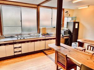 a kitchen with a wooden table and a refrigerator at 神庭武道館 in Chichibu
