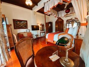 a bedroom with a bed and a table and chairs at Hotel Tropicana Castle Sabang Mindoro in Sabang