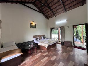 a room with two beds and a table in it at janani ecostay in Chikmagalūr