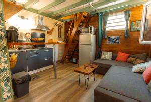 a small living room with a couch and a kitchen at LE TI CITRON VERT - Baignoire à ciel ouvert et refuge coloré - in Saint-Leu