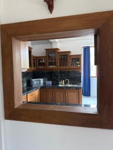a kitchen with wooden cabinets and a mirror at River Breeze Villa in Nikawatawana