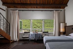 a bedroom with a table and a large window at Mocun Resort in Deqing +32 photos