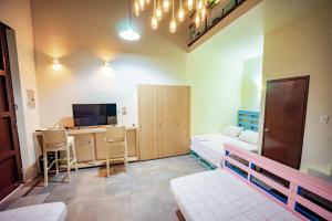a room with a bed and a desk and a tv at Villana's Hostal Santa Marta in Santa Marta