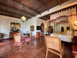 a bedroom with a bed and a table and chairs at Hotel Tropicana Castle Sabang Mindoro in Sabang