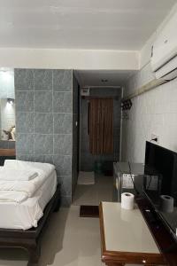 a bedroom with a bed and a desk with a computer at Baan Lanna Resort in Chon Buri