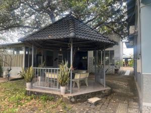 a gazebo with a table and chairs on a house at Khách sạn Vườn Bưởi in Ấp Bình Sơn