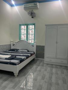 a bedroom with a bed and a cabinet at Khách sạn Vườn Bưởi in Ấp Bình Sơn