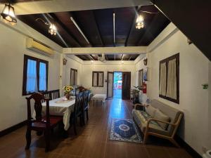 a dining room with a table and chairs and a living room at Mary's House Xiengthong in Luang Prabang