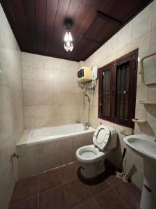 a bathroom with a tub and a toilet and a sink at Mary's House Xiengthong in Luang Prabang