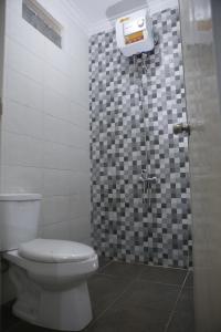 a bathroom with a toilet and a shower at linns house borobudur syariah malang in Blimbing +6 photos