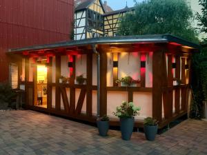 a wooden pavilion with potted plants in front of a building at AltstadtQuartier Rudolstadt Ankommen l Bleiben in Rudolstadt
