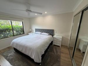 a bedroom with a large bed and a window at Mistral Breeze in Nelson Bay