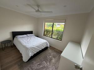 a small bedroom with a bed and a window at Mistral Breeze in Nelson Bay