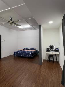 a room with a bed and a table in it at Classic Pearl Homestay in Teluk Intan