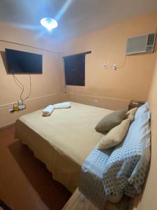a bedroom with a bed and a tv on the wall at Departamento Gallino PB in Corrientes