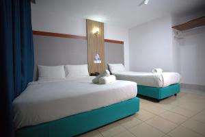 two beds in a hotel room with two beds at Hotel Putra Hills at WTCKL in Kuala Lumpur