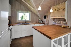 a kitchen with white cabinets and a wooden counter top at 14246-Grevinge-Egenaes-Vaenge-42 in Grevinge