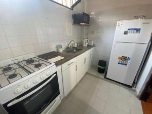 a kitchen with a stove and a white refrigerator at Departamento Gallino PB in Corrientes