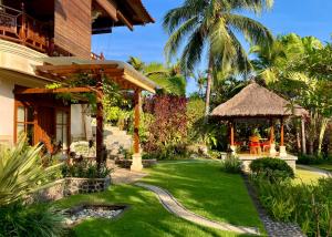a house with a grassy yard with a gazebo at Gunung Paradis Retreat in Munduk