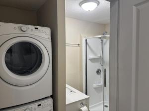 a white washing machine in a bathroom with a shower at Gorgeous 3-Bedroom 3Bathroom house in Kitchener