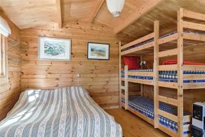 a bedroom with two bunk beds in a log cabin at 10006-Rorvig-Hojsandsparken-3 in Rørvig