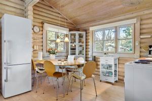 a kitchen with a table and a white refrigerator at 10006-Rorvig-Hojsandsparken-3 in Rørvig