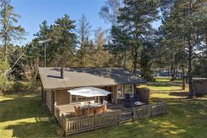 a house with a deck with a table and chairs at 10006-Rorvig-Hojsandsparken-3 in Rørvig