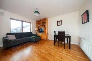 a living room with a couch and a table at Spacious 2BDR Flat Near Portmarnock Beach in Dublin
