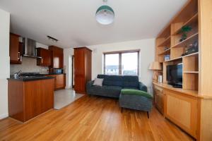 a kitchen and living room with a couch and a tv at Spacious 2BDR Flat Near Portmarnock Beach in Dublin +15 photos