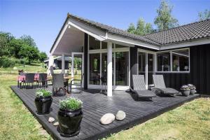 a wooden deck with chairs and a patio at 16623-Farevejle-Stihojvej-14 in Fårevejle