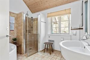 a bathroom with a tub and a shower and a sink at 16610-Farevejle-Mejsevaenget-26 in Fårevejle +18 photos