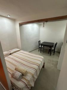 a bedroom with a bed and a table and chairs at Departamento Masha in Tizimín +2 photos