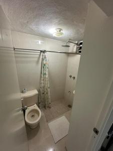 a white bathroom with a toilet and a shower at Departamento Masha in Tizimín