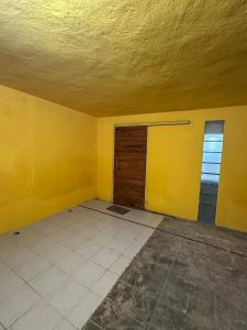 an empty room with a door and a yellow wall at Departamento Masha in Tizimín